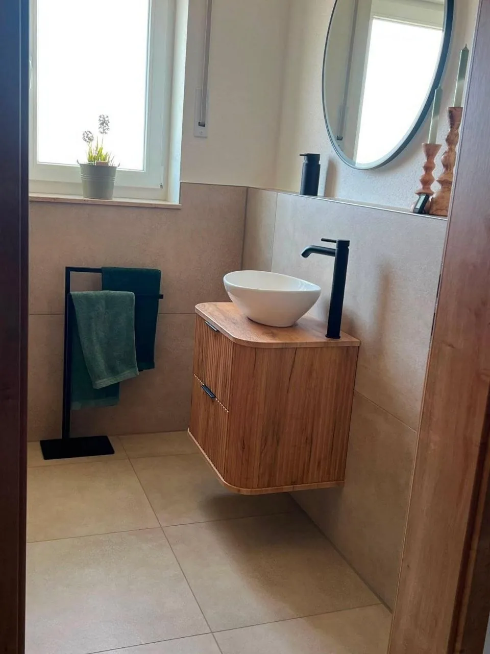 Badezimmer mit Holz-Waschtisch und rundem Aufsatzwaschbecken