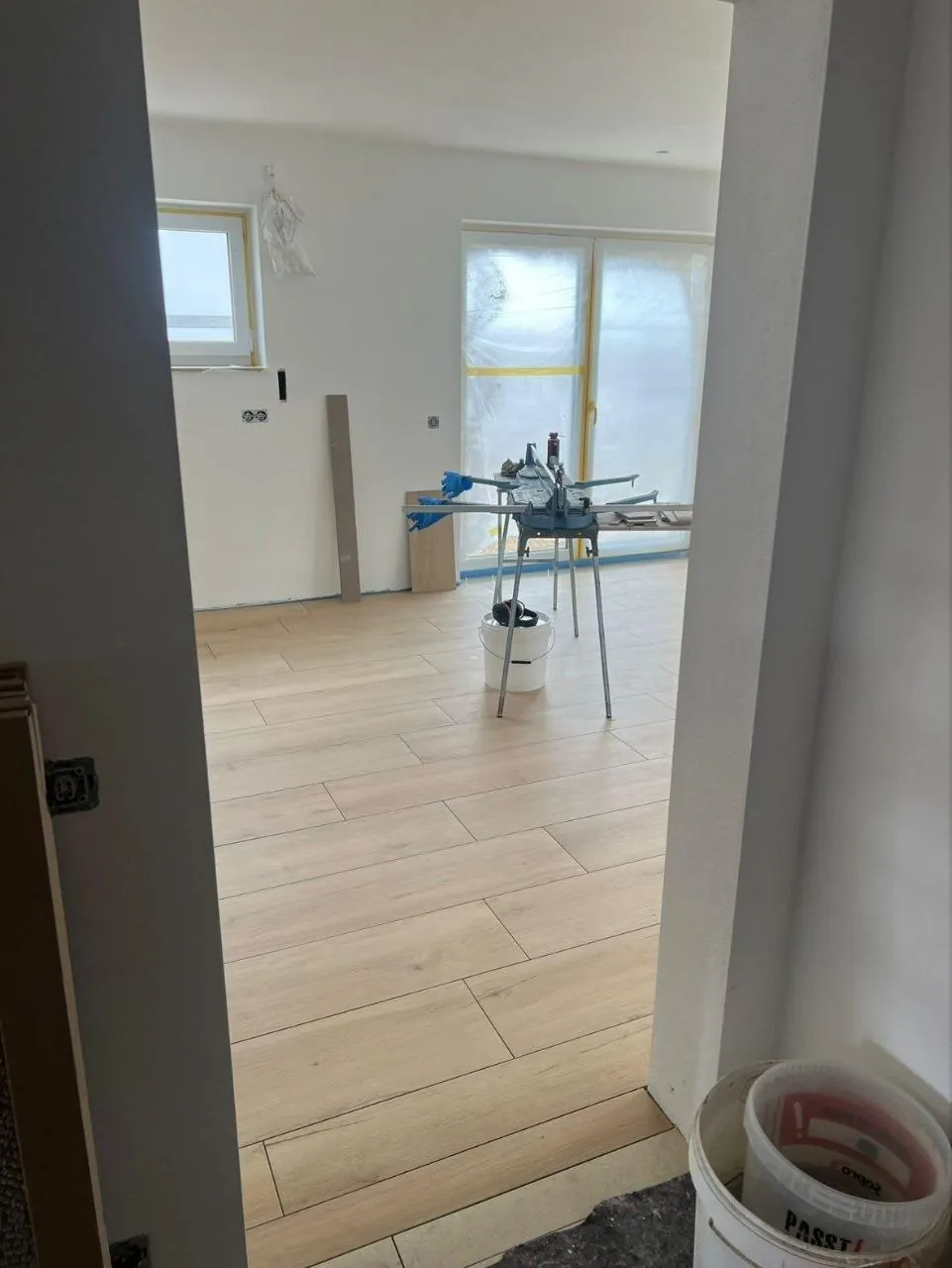 Heller Wohnraum mit fertig verlegtem Boden in Holzoptik