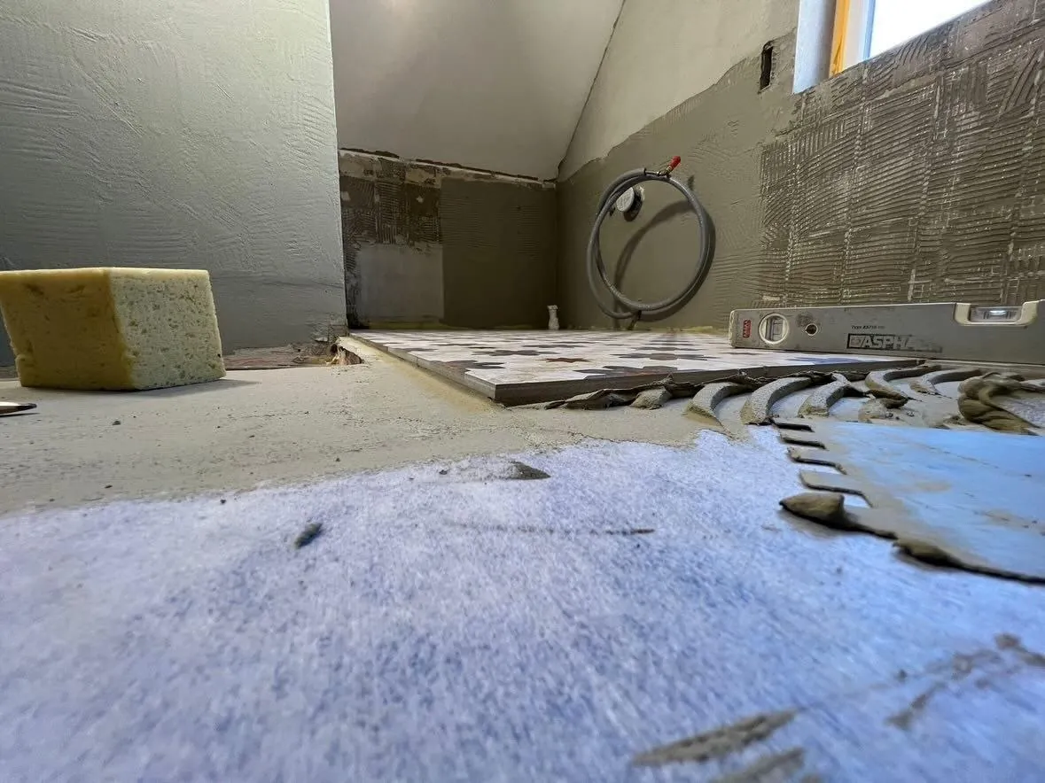 Untergrundvorbereitung im Bad mit Estrich und Naturstein-Wand