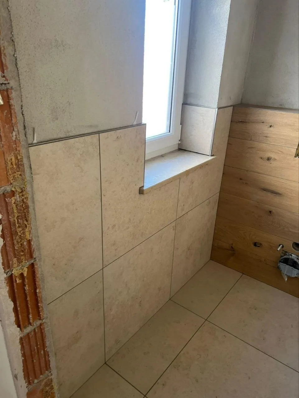 Kleines Dachbad mit beigen Fliesen und Akzentwand in Holzoptik
