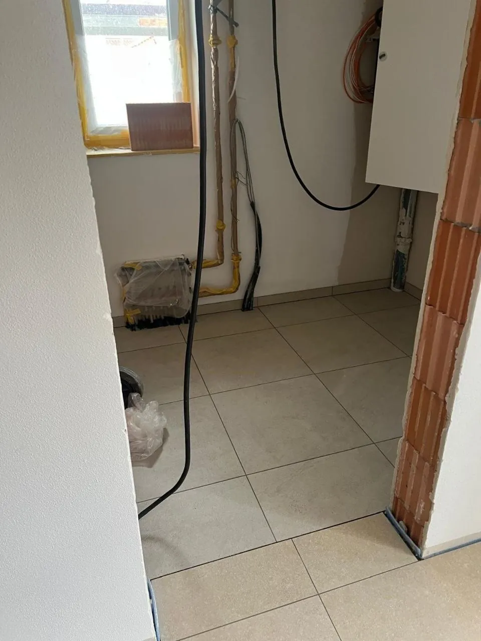 Badsanierung in Arbeit mit beigen Bodenfliesen und teilgefliester Wand
