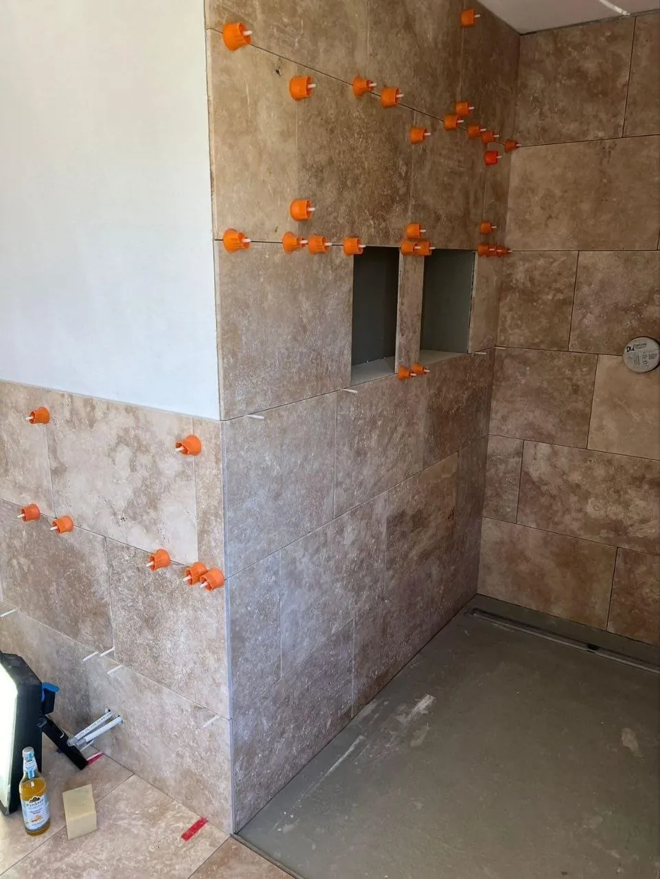 Dusche mit Naturstein-Wandfliesen in warmem Beige